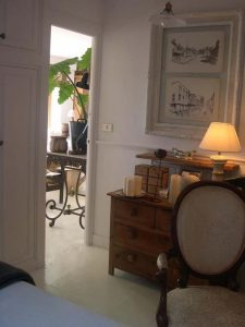 Cómoda de madera rústica con velas y silla clásica en un dormitorio
